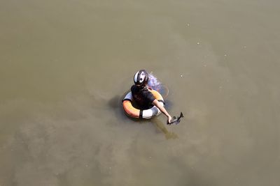 High angle view of person swimming with inflatable ring in lake