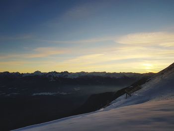 Scenic view of snowcapped mountains against sky during sunset