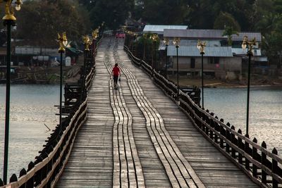 Man walking on railway bridge over water