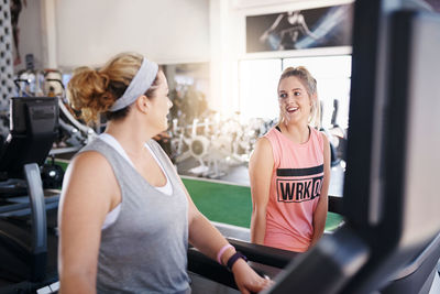 Smiling women talking at gym