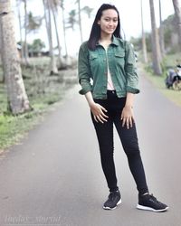 Portrait of young woman standing on road