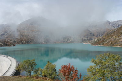 Scenic view of lake by mountains against sky