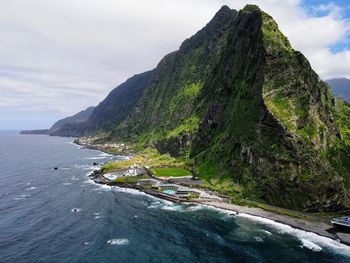 Scenic view of sea and mountains against sky