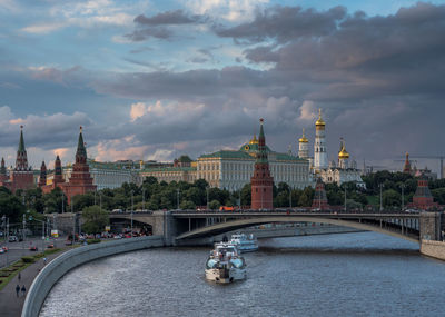 Spasskaya tower by moscva river against cloudy sky