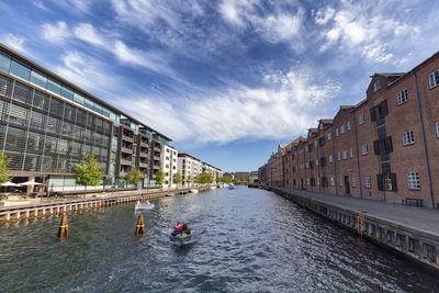 River amidst buildings in city against sky