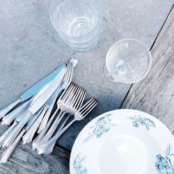 High angle view of empty plates by cutlery