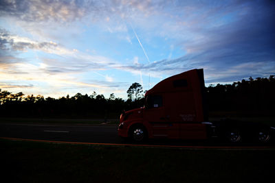 Car on road against sky during sunset