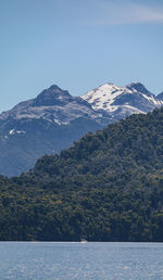 Scenic view of sea by mountains against clear sky