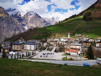 Scenic view of townscape by mountains against sky