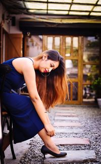 Young woman sitting on seat in park