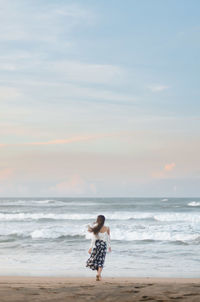 Rear view of woman standing on beach