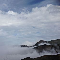 Scenic view of mountains against cloudy sky