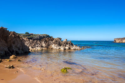 Scenic view of sea against clear blue sky