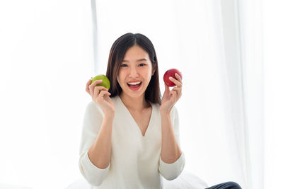 Portrait of a smiling young woman against clear sky