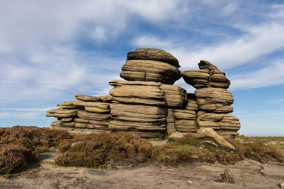 Stack of rocks on rock against sky