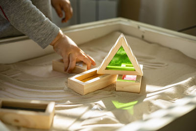 Midsection of person with toy toys on wood