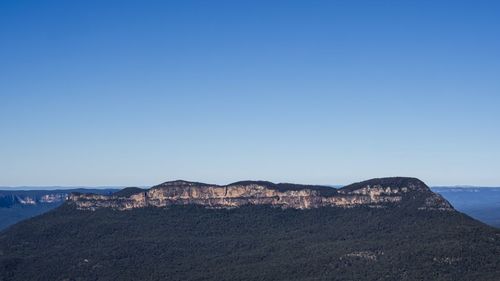 Scenic view of mountains against clear blue sky