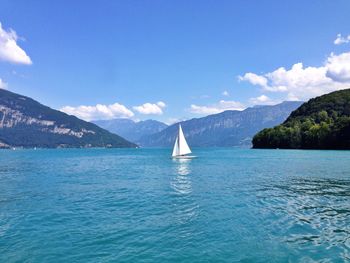 Sailboat sailing on lake against blue sky