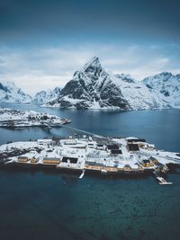 Scenic view of sea and snowcapped mountains against sky