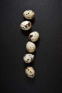 Quail eggs on a black table.