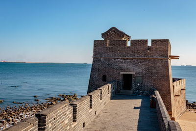 Castle by sea against clear sky