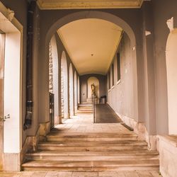 Rear view of man walking in corridor of building