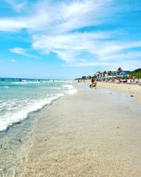 Scenic view of beach against cloudy sky