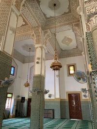 Low angle view of illuminated chandelier hanging in building