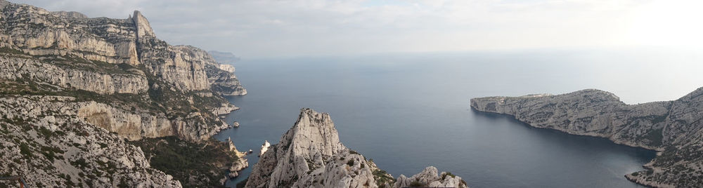 Panoramic view of rock formations in sea against sky