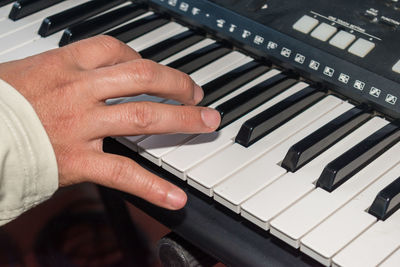 Cropped hand of man playing piano