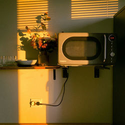 Close-up of illuminated lamp against wall at home