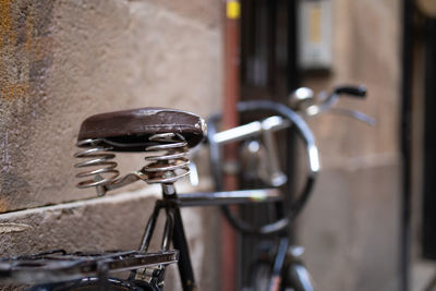 Close-up of bicycle parked against wall