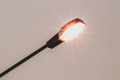 Close-up of illuminated lamp against sky during sunset