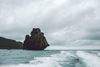 Rock formation in sea against sky