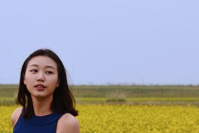 Portrait of beautiful young woman against clear blue sky