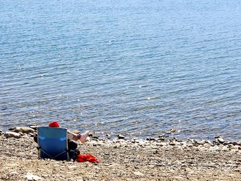 Rear view of woman sitting on beach