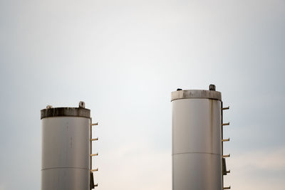 Smoke stacks against light cloud  cover 