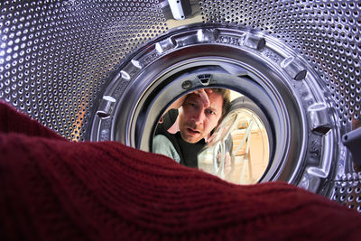 Portrait of man seen through washing machine