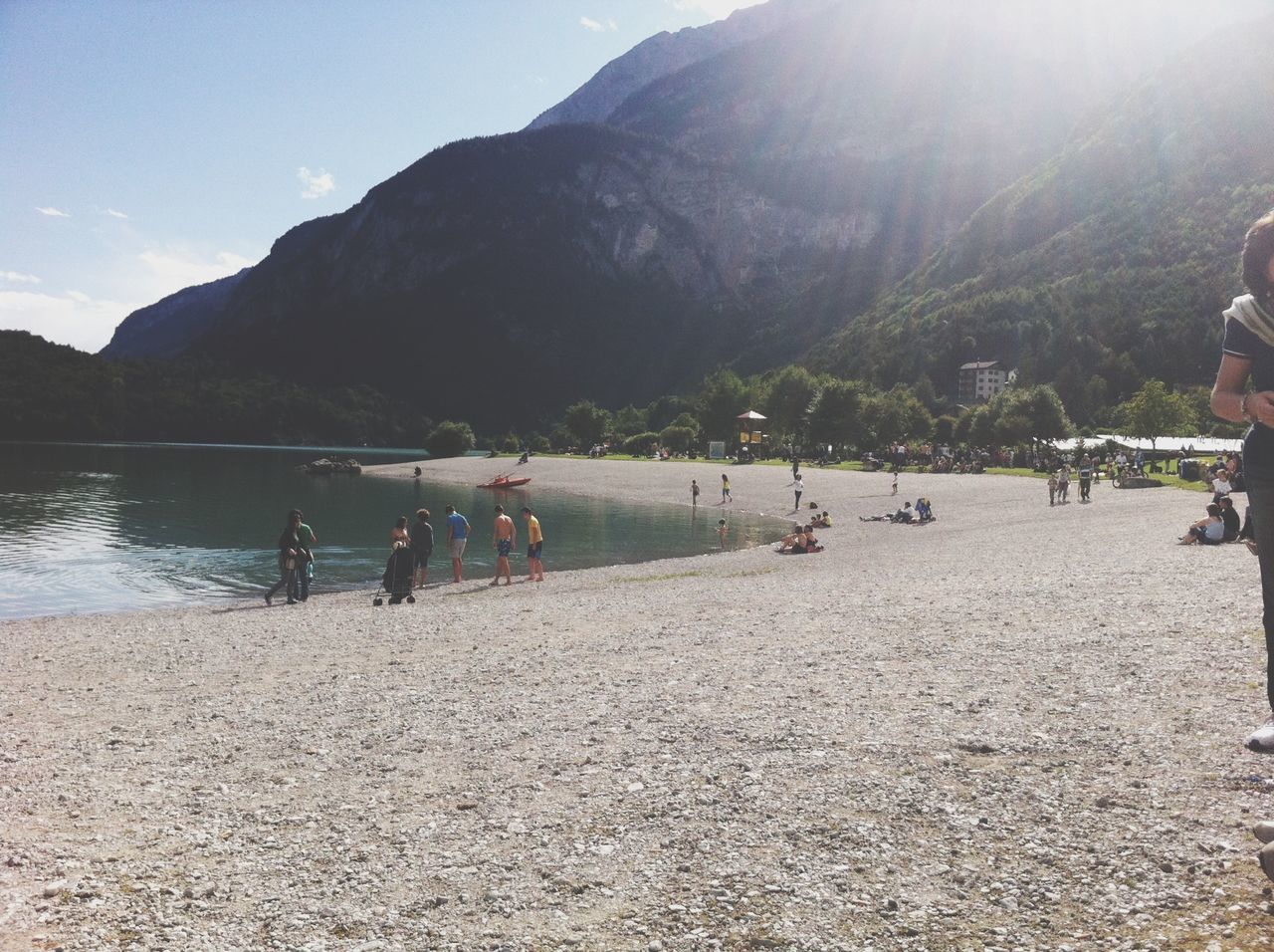 mountain, water, scenics, tranquil scene, tranquility, sky, beach, mountain range, beauty in nature, sea, nature, transportation, incidental people, large group of people, shore, sand, vacations, nautical vessel, lake