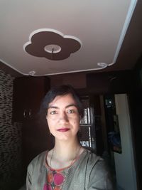 Portrait of smiling woman standing at home