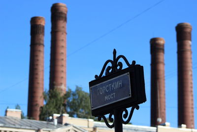 Low angle view of information sign against clear blue sky