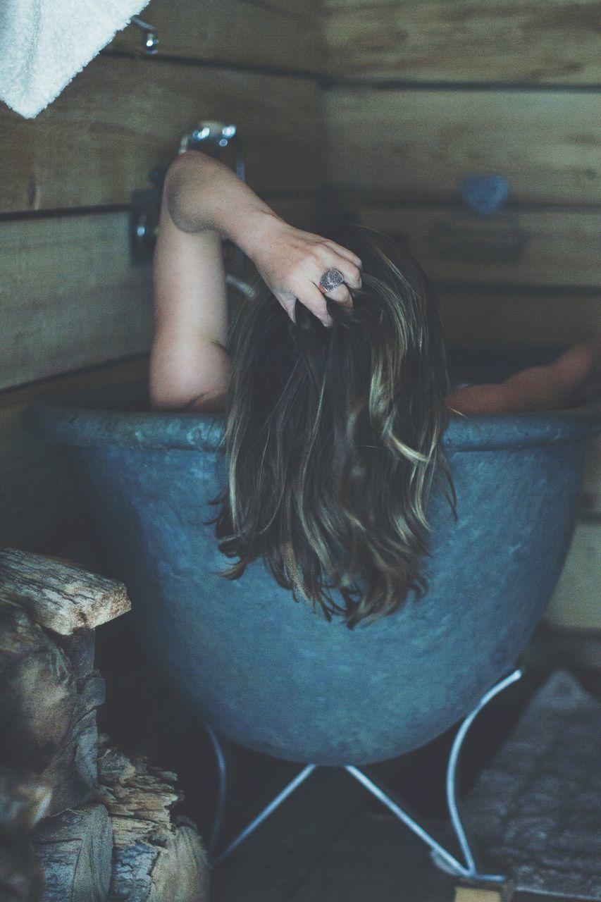 YOUNG WOMAN SITTING AT HOME