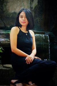 Portrait of beautiful young woman sitting outdoors