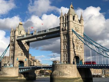 Low angle view of tower bridge over thames river against cloudy sky