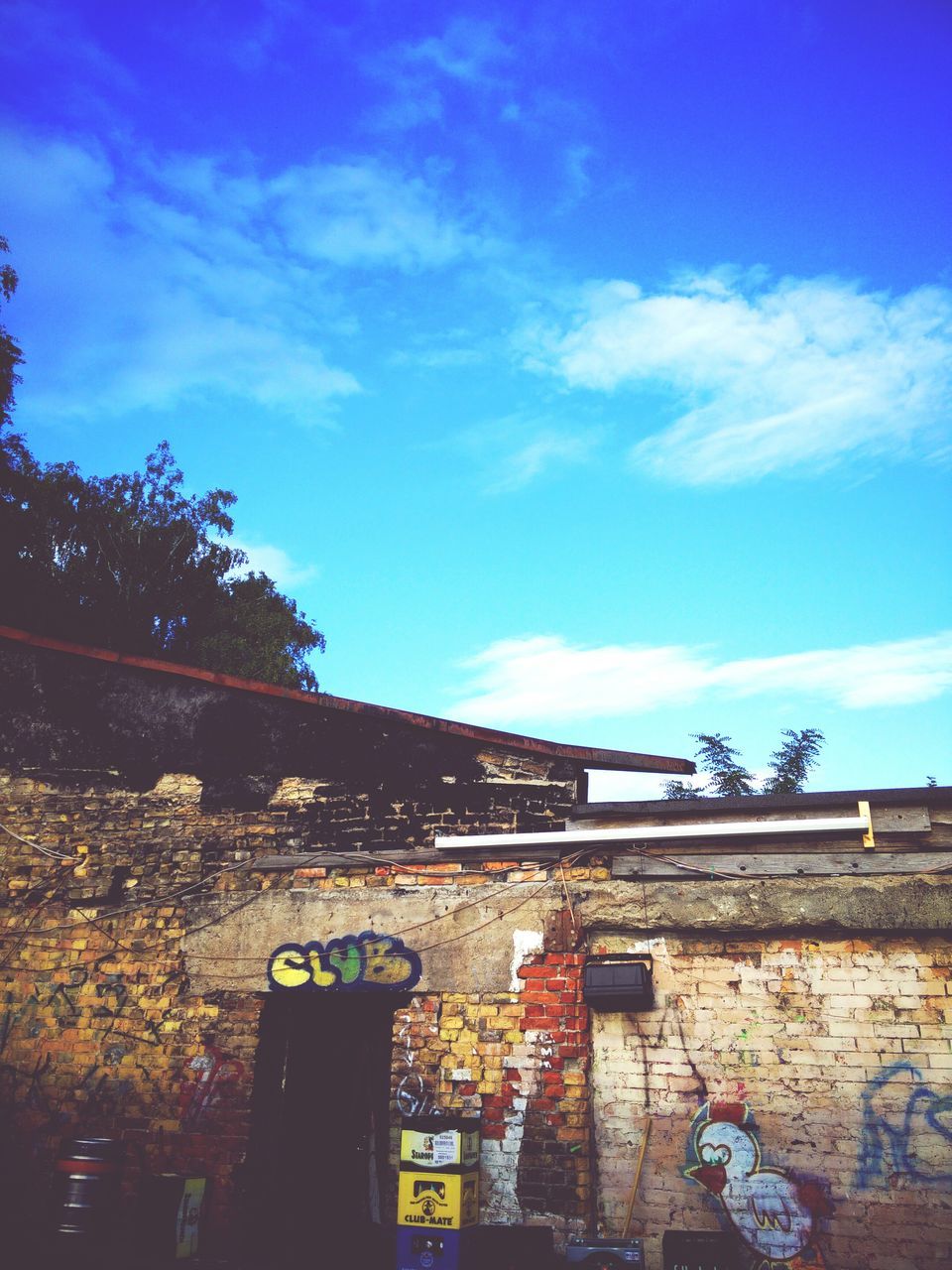 building exterior, architecture, built structure, low angle view, sky, blue, tree, building, cloud - sky, house, residential building, residential structure, cloud, outdoors, brick wall, no people, sunlight, day, city, window