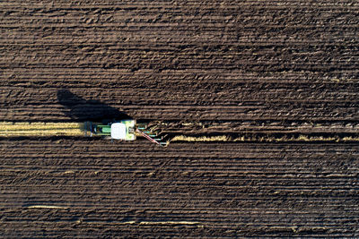 A tractor is preparing the field for the winter. the last furrow is under way.