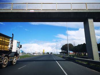 Vehicles on highway against sky