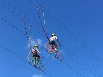 Low angle view of electricity pylon against clear blue sky