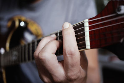 Midsection of man playing guitar