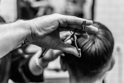 Hairdresser cutting boy hair at salon